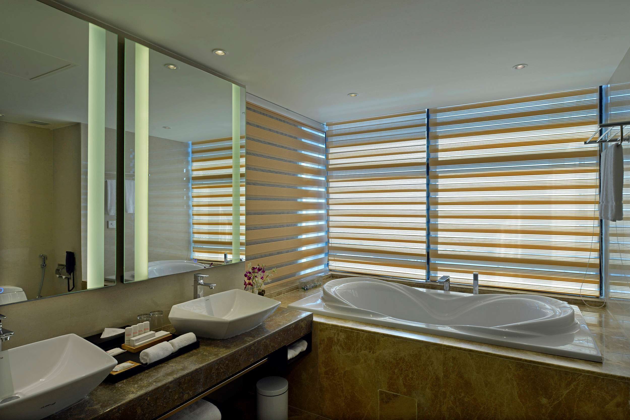 A modern bathroom with a large sink, a bathtub, and a mirror.