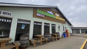 A Badlands Motel with a closed restaurant sign, outdoor seating, and a 'No Vacancy' sign. - Badlands Motel (Drumheller)