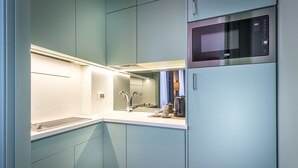 A modern kitchen with a built-in microwave, a sink, and a coffee maker. - La Torre Dei Salterelli (Florence)