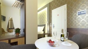 A hotel room with a round dining table, a bowl of fruit, a bottle of wine, and a wine glass. - La Torre Dei Salterelli (Florence)