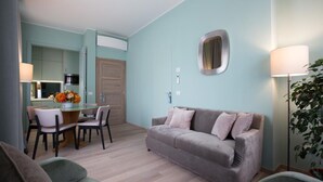 A modern living room with a grey sofa, a dining table with chairs, and a kitchen area in the background. - La Torre Dei Salterelli (Florence)