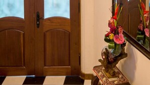 A checkered floor, a wooden door with frosted glass panels, and a small table with a vase of flowers. - My Hotel in Puerto Rico (San Juan)