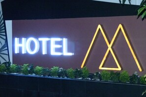 A hotel sign with the word "HOTEL" and a stylized 'M' logo. - Hotel M (Yangon)