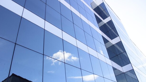 A modern building with a reflective glass facade and a clear sky in the background. - Floresta Hotel - Expo Anhembi (São Paulo)