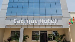 A hotel with a modern glass facade and a sign reading "Carique Hotel". - El Cacique Hotel (Piura)