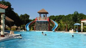 En swimmingpool med två vattenrutschkanor och en liten paviljong.