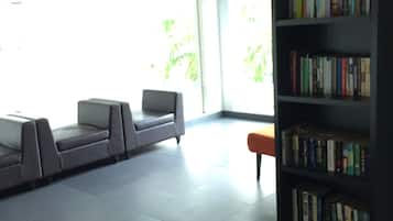 A modern reading area with a sofa, a small table, and a bookshelf.