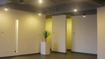 Un interior espacioso y luminoso con un diseño minimalista, que presenta una planta grande en maceta y un ventanal largo y estrecho.