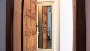 A wooden door with a mirror reflecting a staircase and a light fixture. - 19 Oda Bozcaada (Adults Only) (Bozcaada)