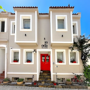 A two-story building with a red door, numbered 19, and a sign reading "Oda Bozcanada". - 19 Oda Bozcaada (Adults Only) (Bozcaada)