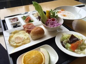 A tray with various food items including an omelette, bread, salad, and a bowl of soup. - Goya Spring Resort (Taichung)