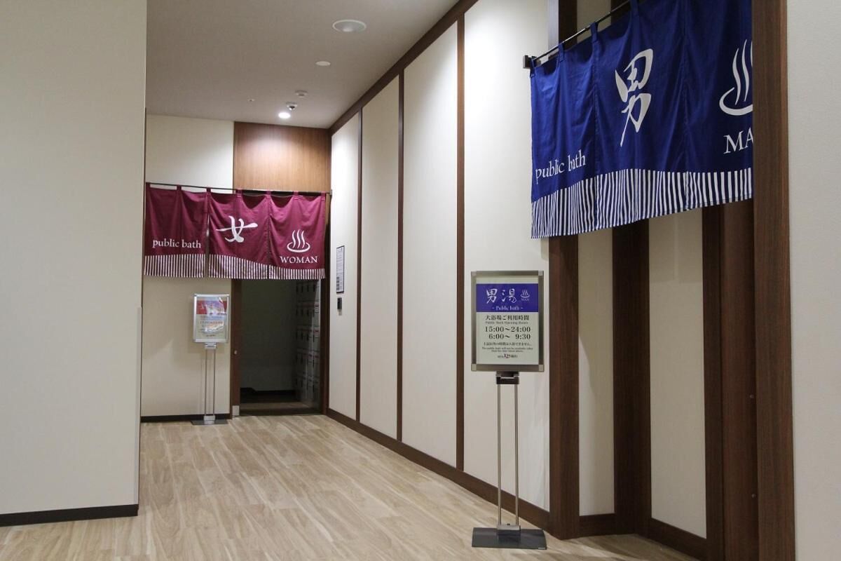 A hallway with wooden paneling, a public bath sign, and banners for public bath and women.