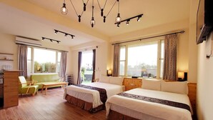 A hotel room with two beds, a sofa, a coffee table, and a desk. - Cai Feng B&B (Ji'an)