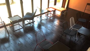 Ein Zimmer mit Holzboden, einer Couch, einem Tisch und einigen Stühlen.