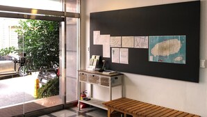 A reception area with a wooden bench, a wall-mounted map, and a fire extinguisher.