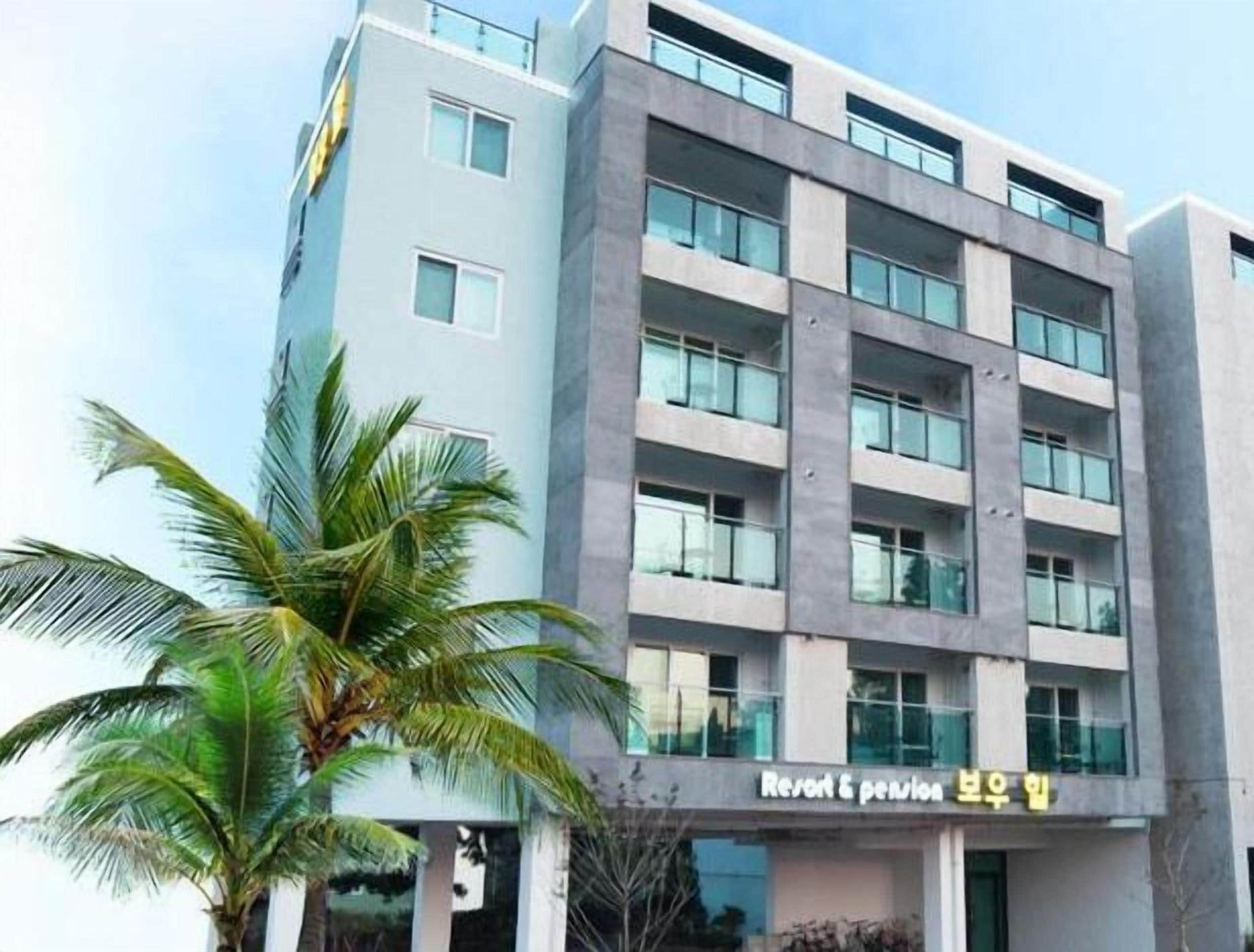 A multi-story building with a modern architectural design, featuring a prominent entrance and a sign indicating it is a hotel.