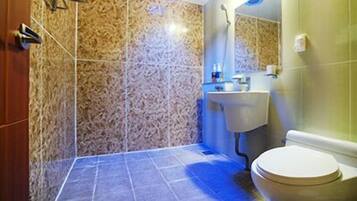 Une salle de bain avec un mur en marbre, un lavabo et des toilettes.