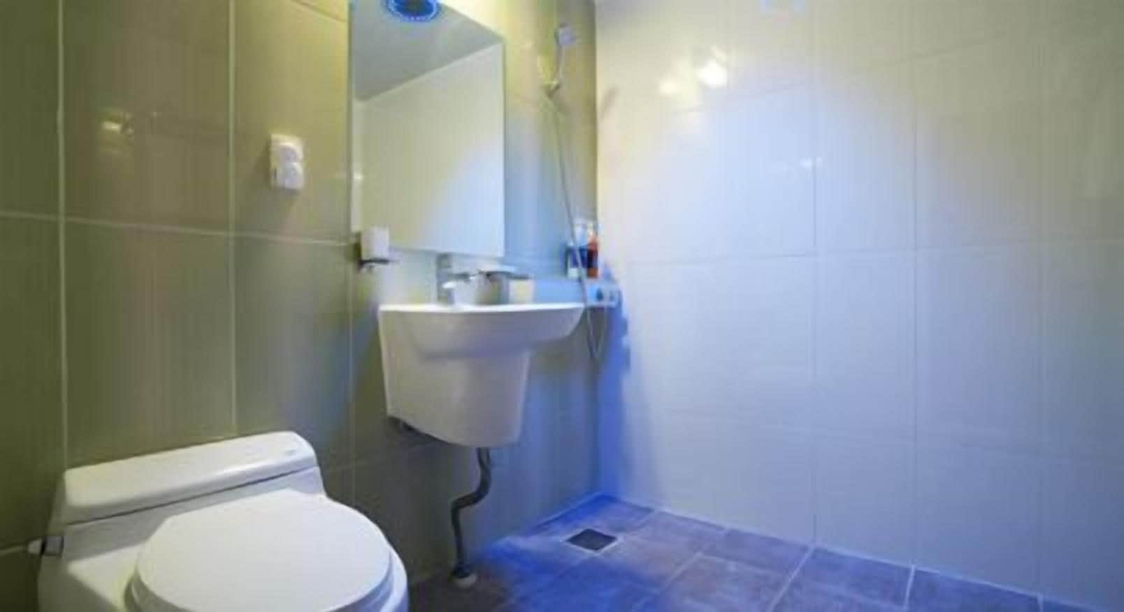 A bathroom with a toilet, sink, and shower.