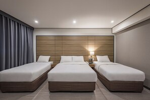 A hotel room with three beds, a wooden headboard, a nightstand with a lamp, and a large window with curtains. - Insadong Crown Hotel (Seoul)
