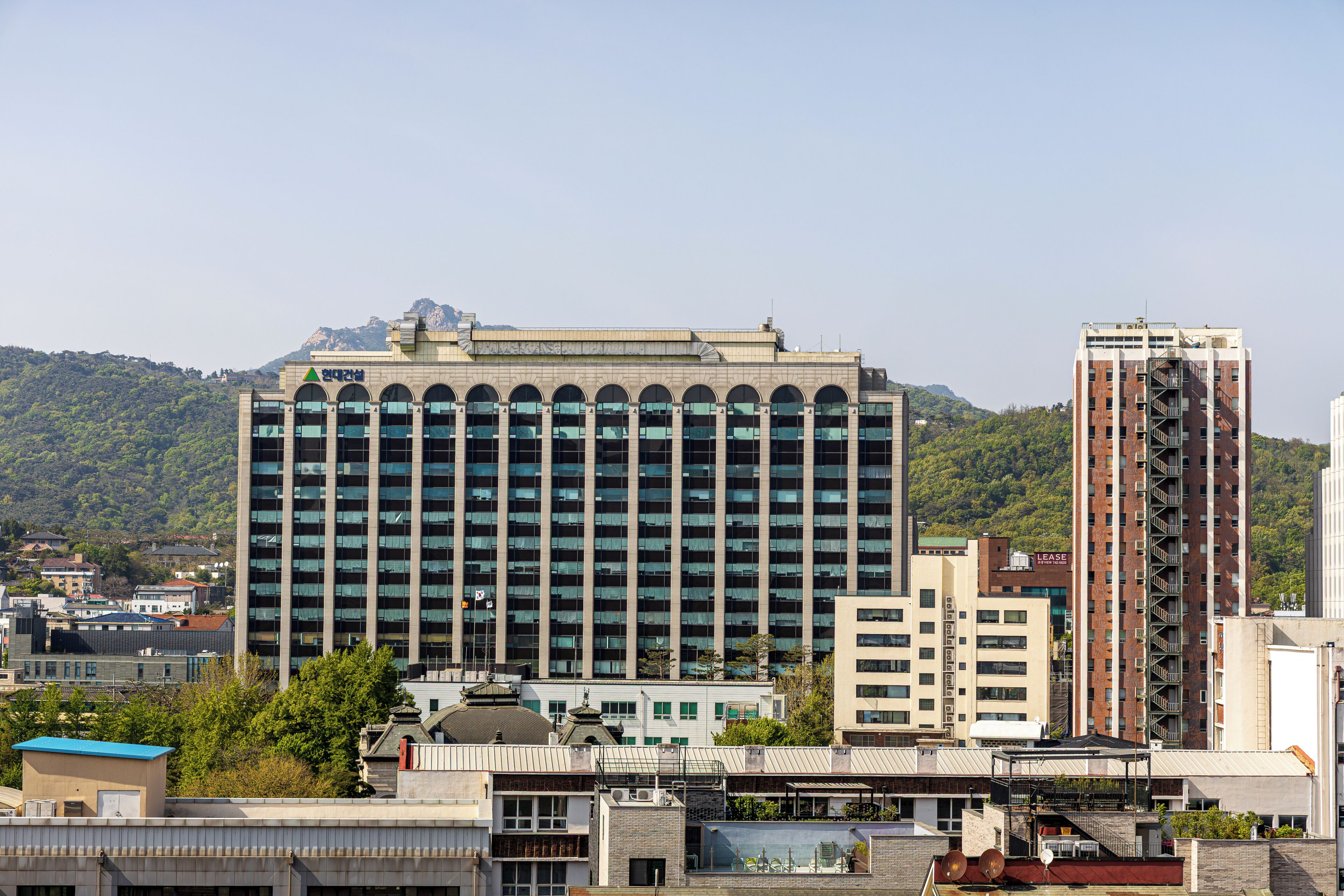 A multi-story building with a flat roof, large windows, and a sign with Korean characters.