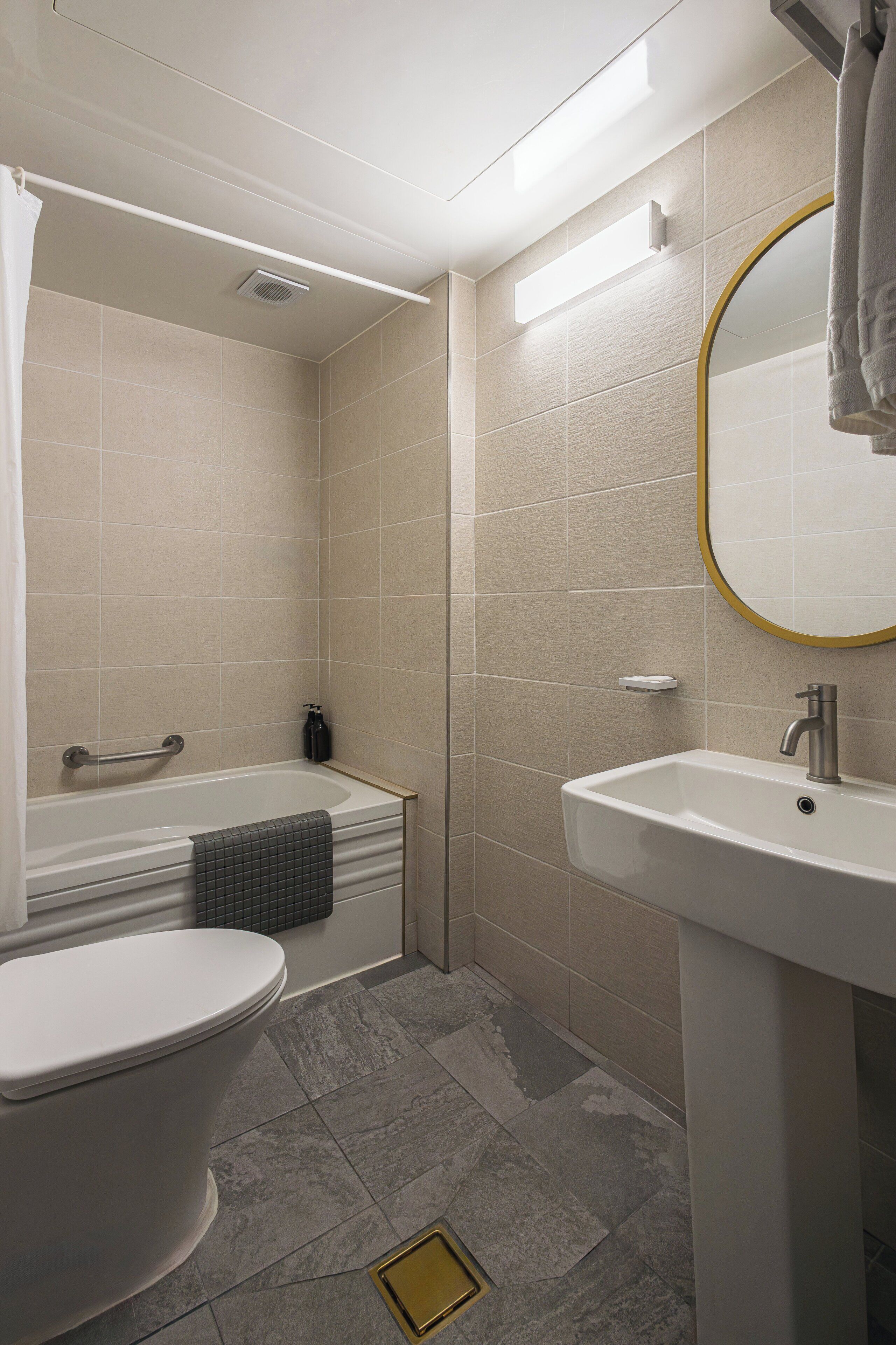 A bathroom with a toilet, bathtub, and sink.
