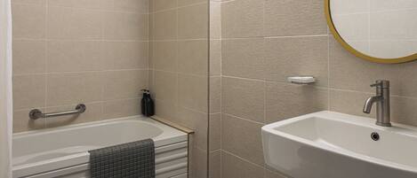 A bathroom with a toilet, bathtub, and sink.