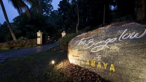 A large rock with the inscription "The Bringa Low AMAYA" in a garden setting at dusk. - Hanthana Boutique Villa by Amaya (Kandy)