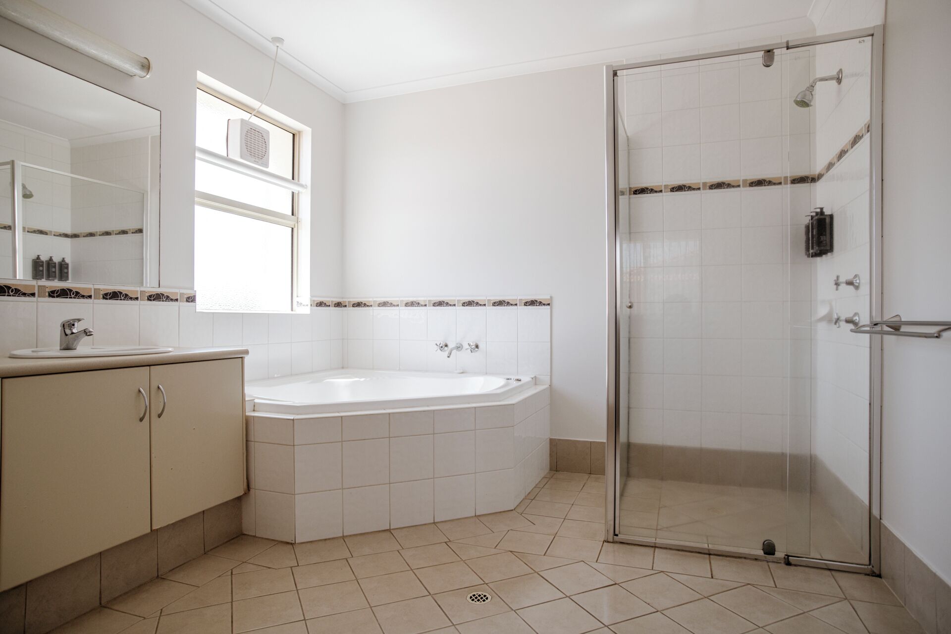 Un baño con bañera, cabina de ducha de vidrio y tocador con espejo.
