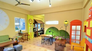 A cozy room with a large clock, a green sofa, a wooden table, and a red door. - I'm Here B&B-Peng's family (Taitung)