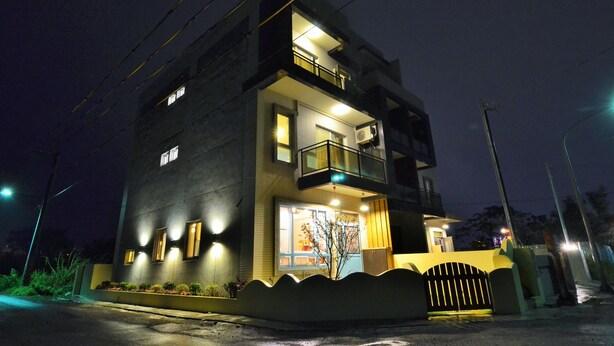 A modern two-story building with a balcony on the upper floor, a gated entrance, and a well-lit facade. - I'm Here B&B-Peng's family (Taitung)