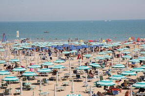 A beach with numerous umbrellas and sun loungers.