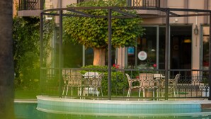 A pool area with a covered seating area and a building in the background. - Golden Moon Hotel (Fethiye)