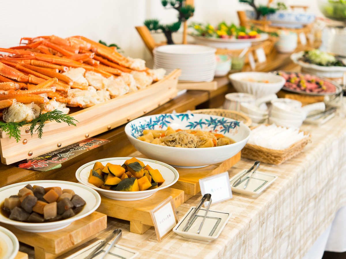 A buffet table with various dishes including seafood, vegetables, and other foods.