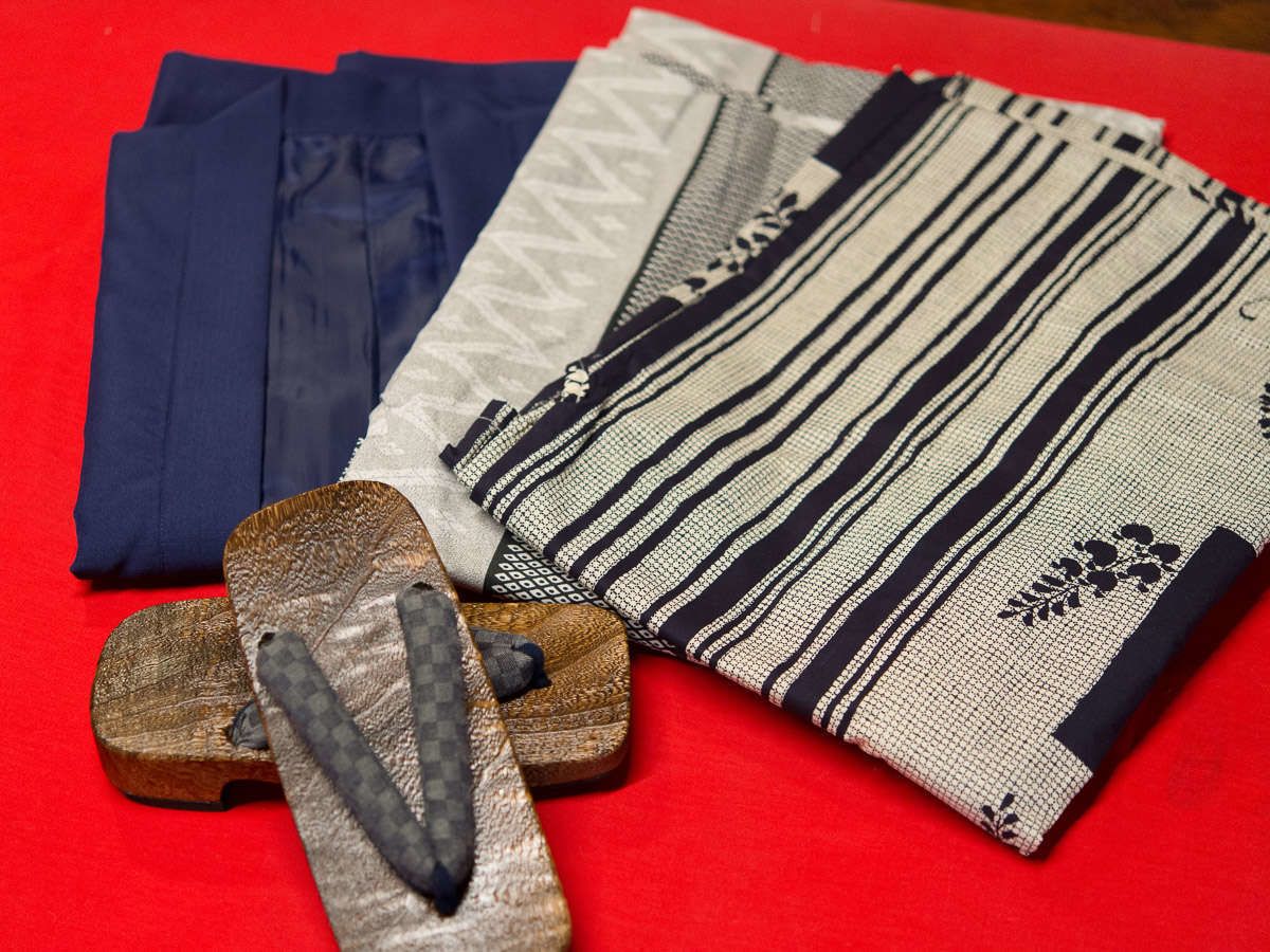 Superficie roja con textiles doblados y una herramienta de madera.
