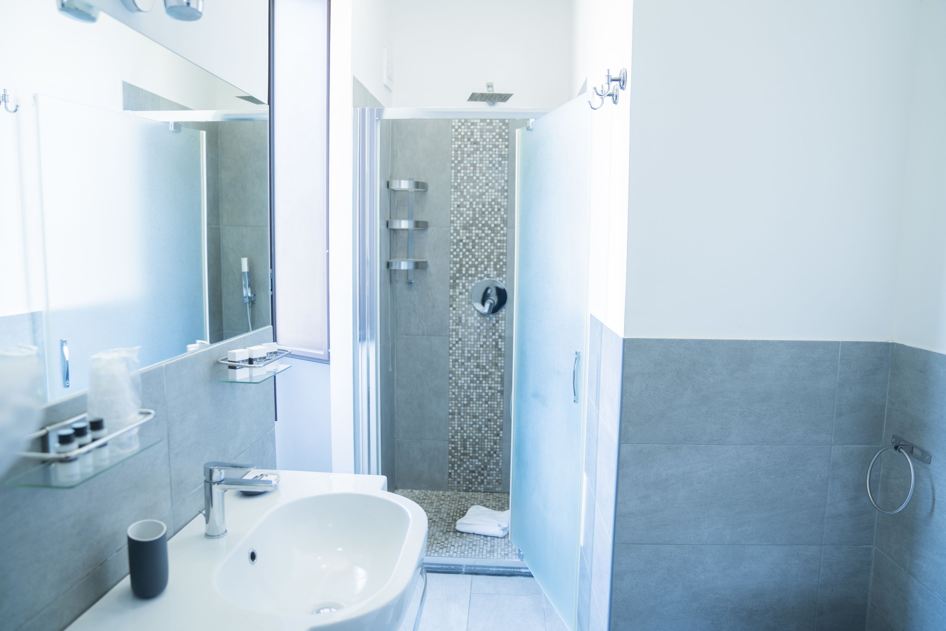 Een moderne badkamer met een groot wastafel, spiegel en douche.