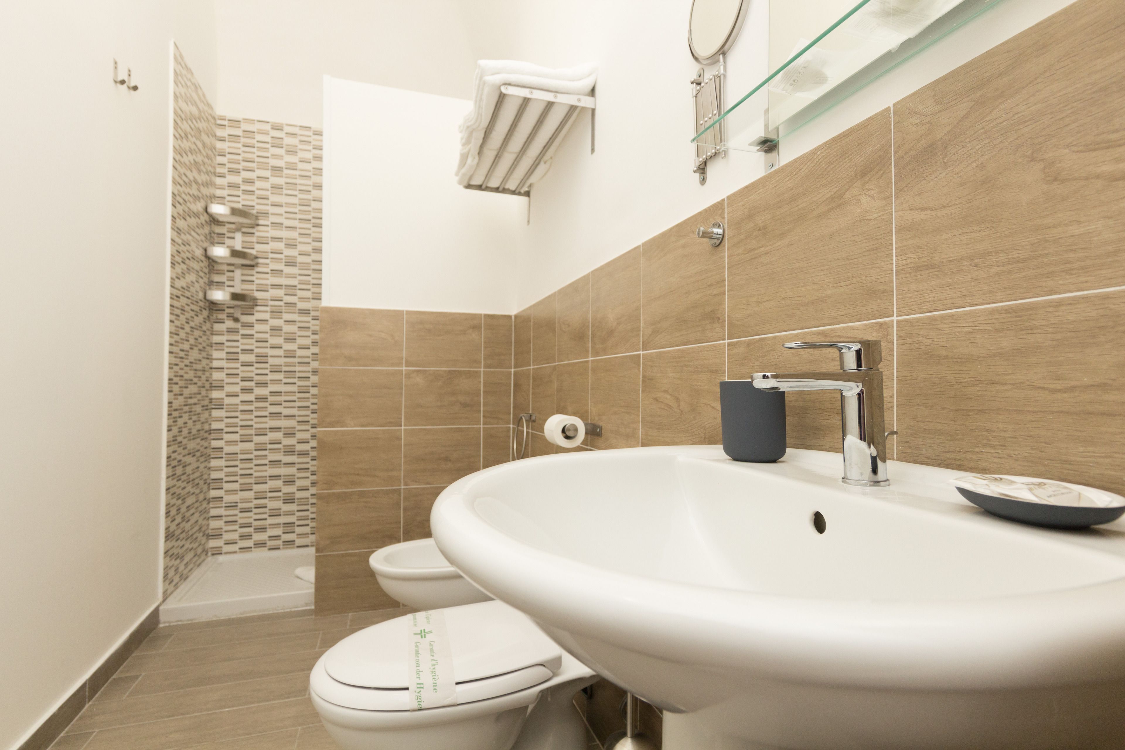 A modern bathroom with a sink, toilet, and shower.