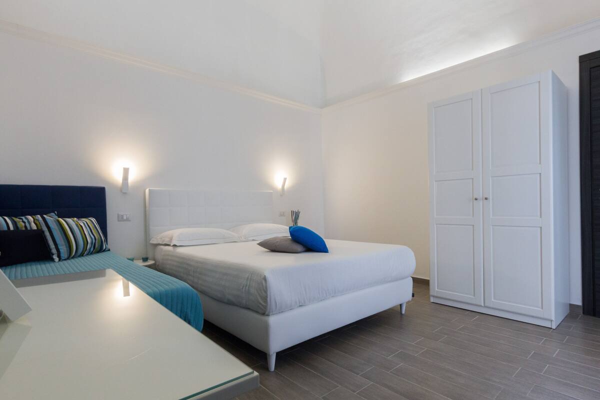 Una camera da letto moderna con un letto grande, comodini e un armadio.