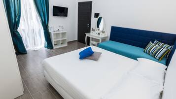 Une chambre d’hôtel avec un lit, un bureau, une chaise, une télévision et une porte.