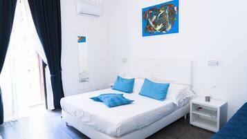 Un dormitorio moderno con una cama grande, una mesita de noche y una obra de arte colgada en la pared.