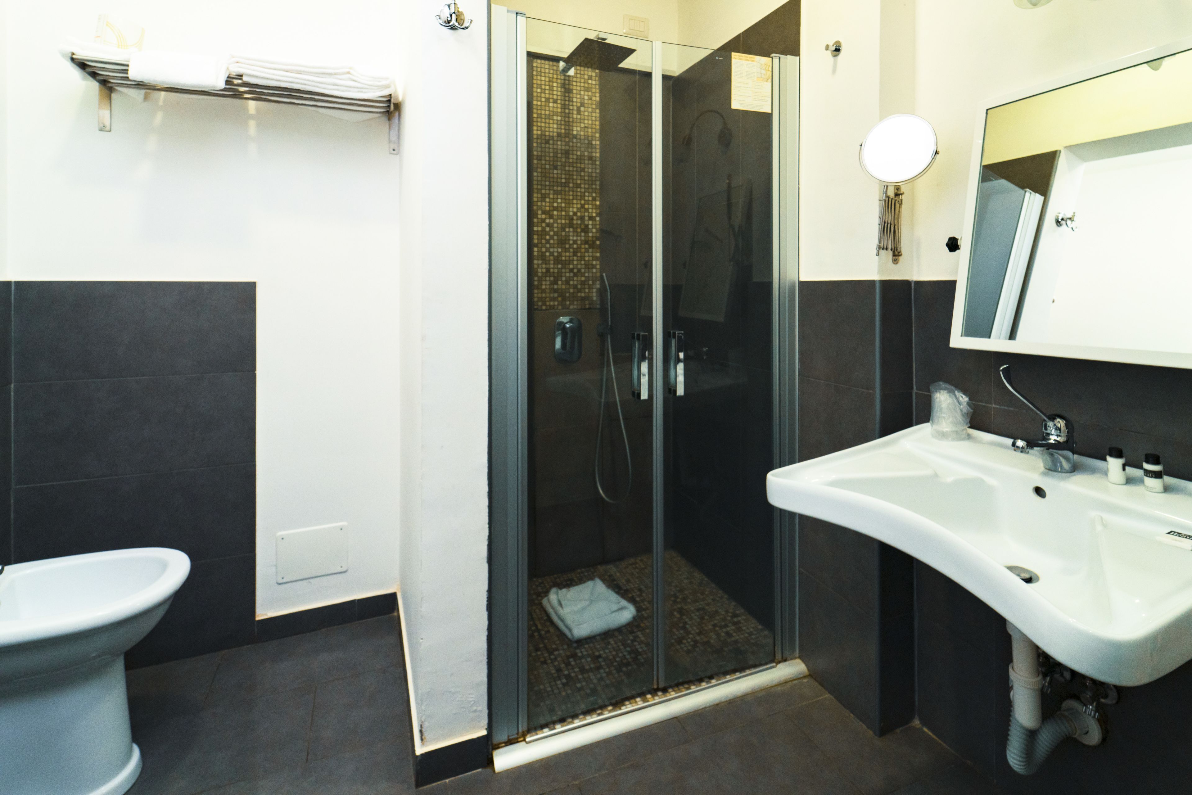 Ein modernes Badezimmer mit einer Duschkabine, einem weißen Waschbecken und einer Toilette.