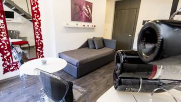 A modern living room with a sofa, a round table, and a large mirror with a decorative frame.