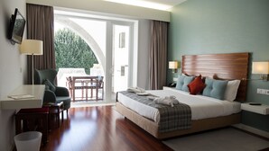 A hotel room with a large bed, a desk, a chair, a television, and a view of the outdoors. - Hotel São Bento da Porta Aberta & Spa (Terras de Bouro)