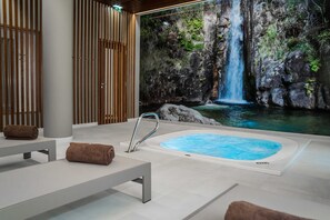 A spa area with a hot tub, wooden slats, and a waterfall mural. - Hotel São Bento da Porta Aberta & Spa (Terras de Bouro)