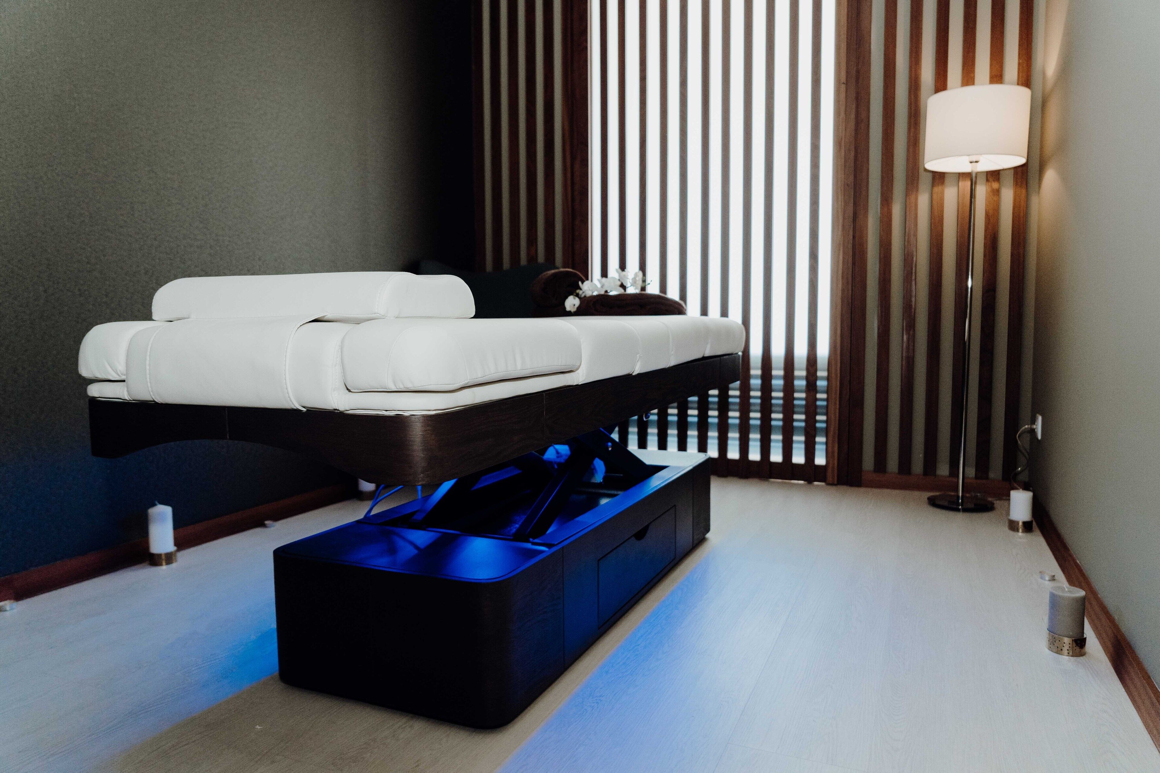 A modern bedroom with a bed, bedside table, and a floor lamp.