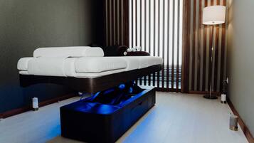 Un dormitorio moderno con cama, mesita de noche y lámpara de pie.