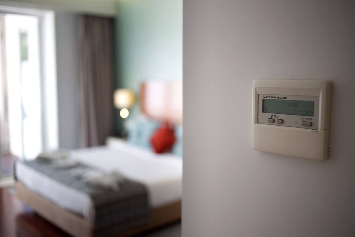 A thermostat on a wall in a hotel room.