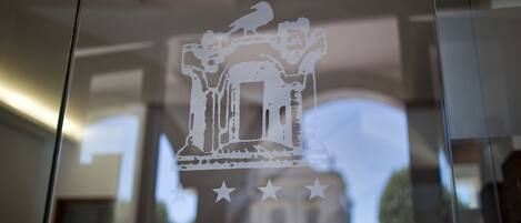 A glass window with a white paper cut-out of a building and a bird.