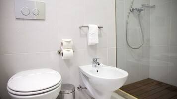 Un baño moderno con inodoro, bidé y ducha.