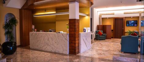 A reception area with a marble counter, wooden accents, and a modern design.