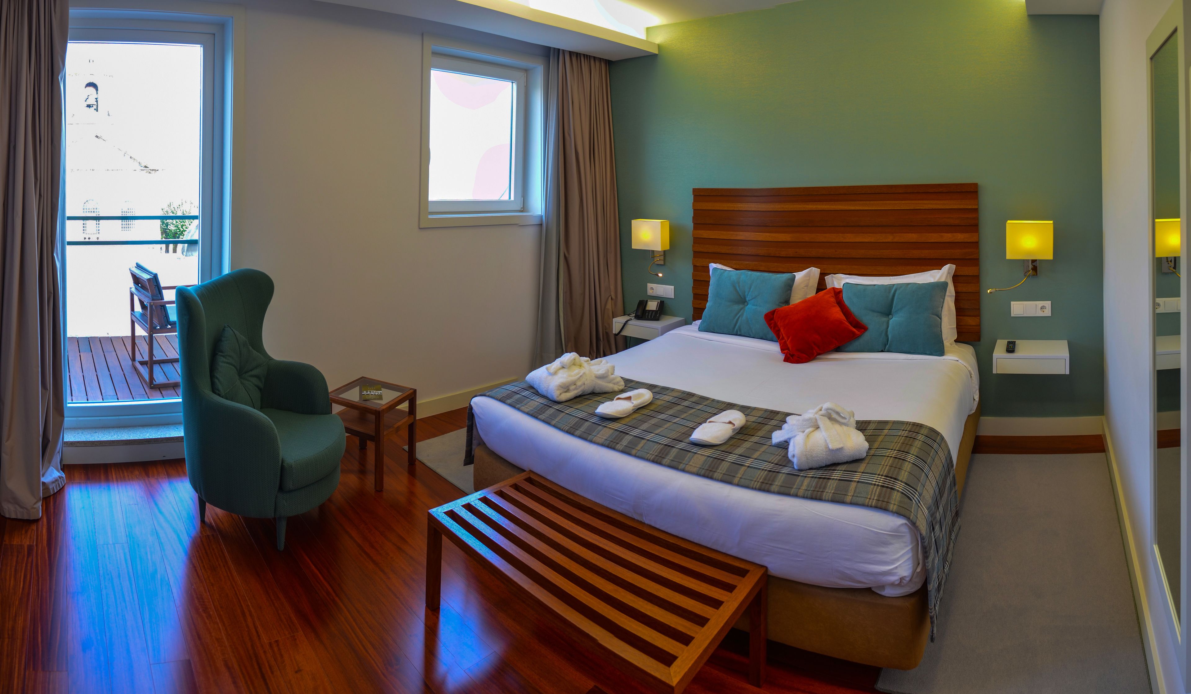 Een hotelkamer met een bed, een stoel, een tafeltje en een raam.